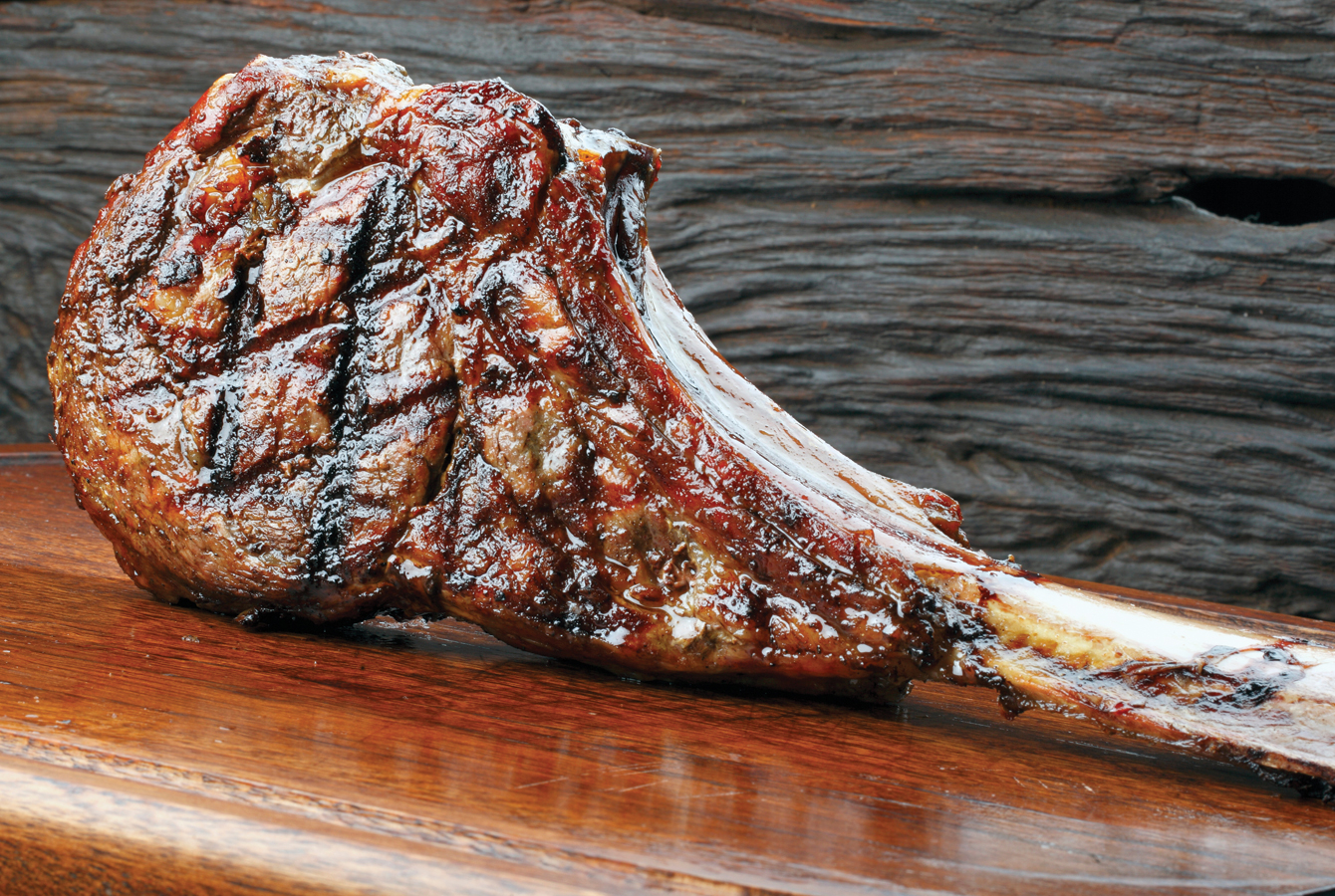 A grilled Tomahawk steaks with grill marks on it, ready to be served and enjoyed.